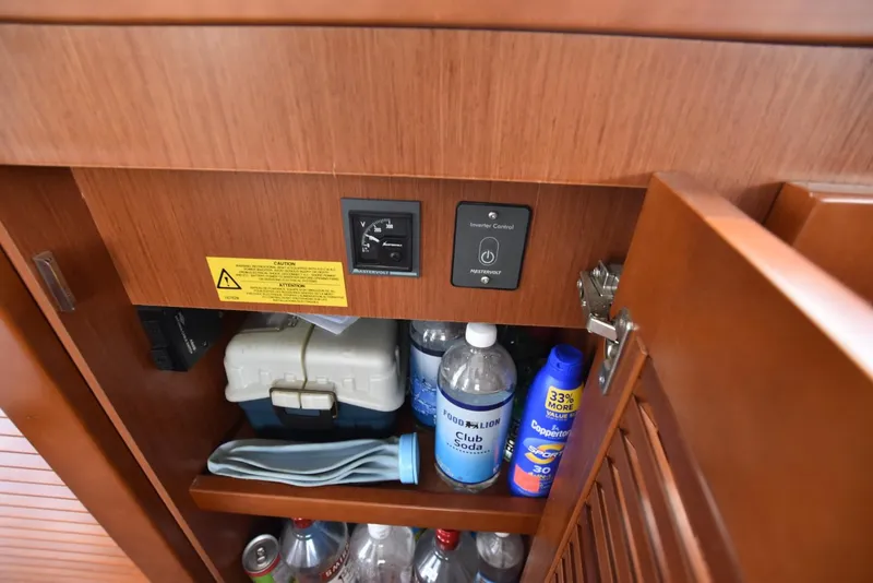 Slide: The Image of Cabinet interior on 2019 Beneteau Swift Trawler 44 with inverter control and storage items. - 27