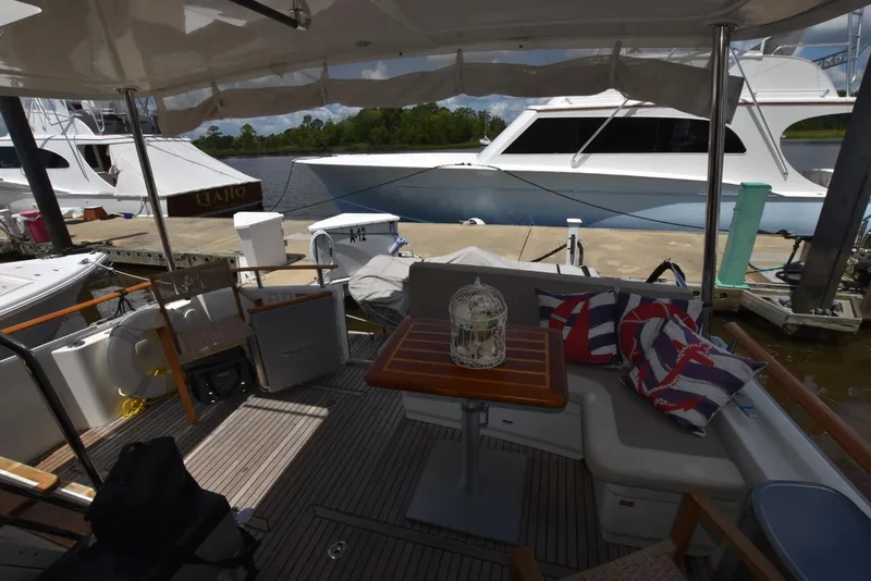 Slide: The Image of 2019 Beneteau Swift Trawler 44 interior with seating, table, and nautical decor at dock. - 30