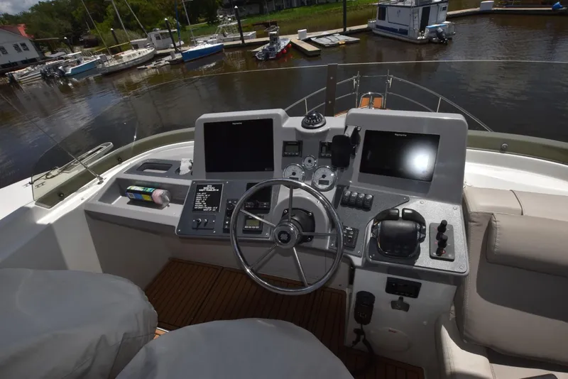 Slide: The Image of Helm of 2019 Beneteau Swift Trawler 44 with navigation equipment and controls, docked by the water. - 42