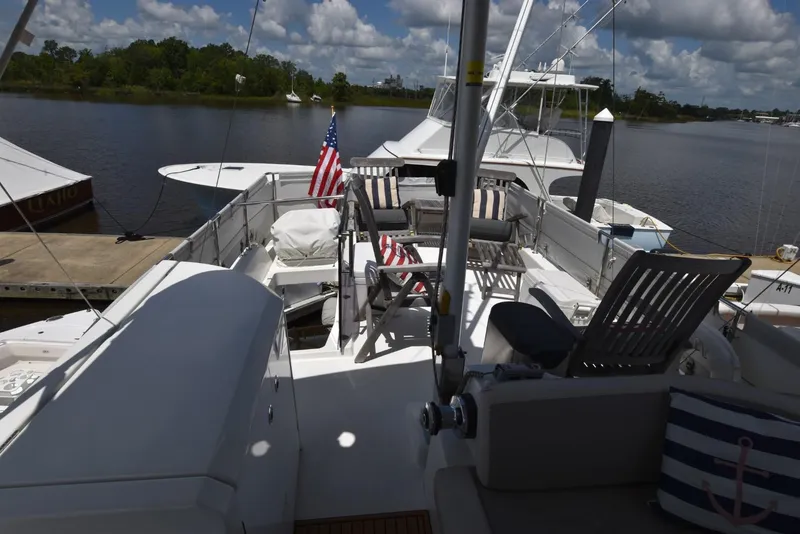 Slide: The Image of 2019 Beneteau Swift Trawler 44 docked, featuring spacious deck with chairs and American flags. - 44