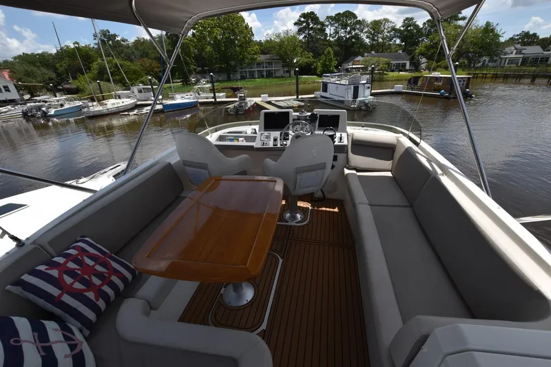 Slide: The Image of Flybridge of 2019 Beneteau Swift Trawler 44 with seating, table, and helm station. - 46