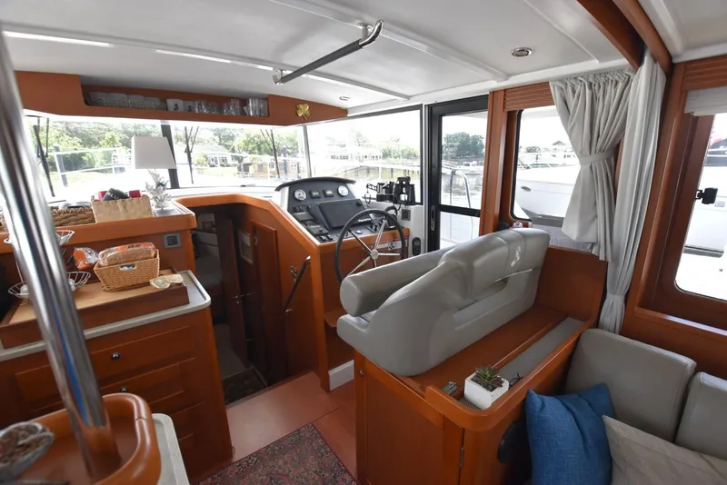 Slide: The Image of Interior of 2019 Beneteau Swift Trawler 44, featuring helm, seating, and kitchen area. - 6