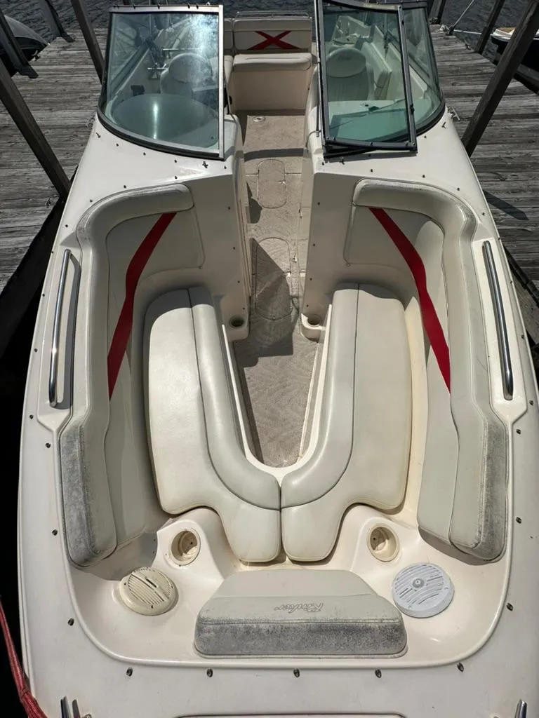 Slide: The Image of 2005 Rinker 282 Captiva Bowrider with white and red seating, docked at a marina. - 15