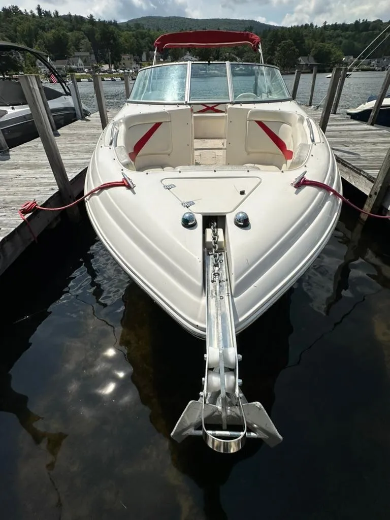 Slide: The Image of 2005 Rinker 282 Captiva Bowrider docked at a scenic lakeside marina. - 3