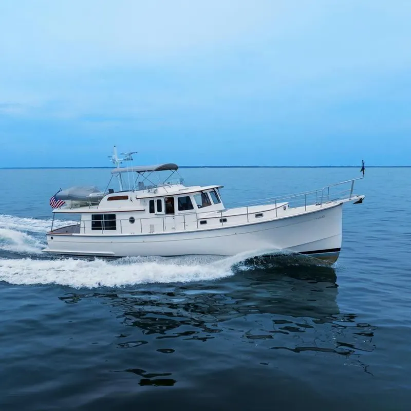 Slide: The Image of 2023 Krogen Express 52 yacht cruising on calm blue waters. - 0