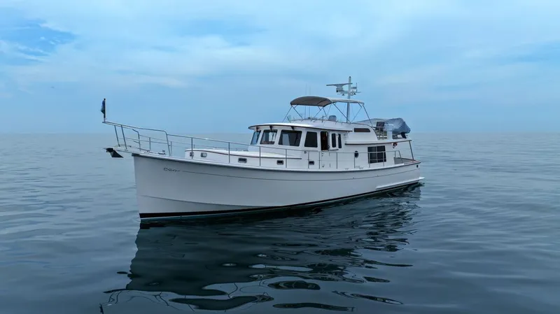 Slide: The Image of 2023 Krogen Express 52 yacht on calm ocean waters under a clear sky. - 10