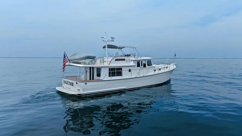 Slide: The Image of 2023 Krogen Express 52 yacht cruising on calm blue waters. - 15