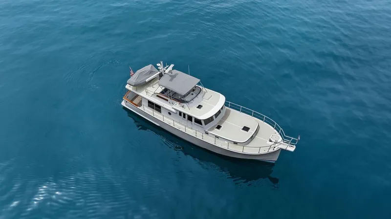 Slide: The Image of 2023 Krogen Express 52 yacht cruising on calm blue waters. - 16