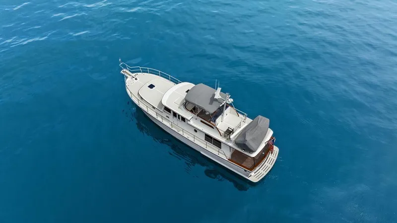 Slide: The Image of 2023 Krogen Express 52 yacht cruising on clear blue water. - 17