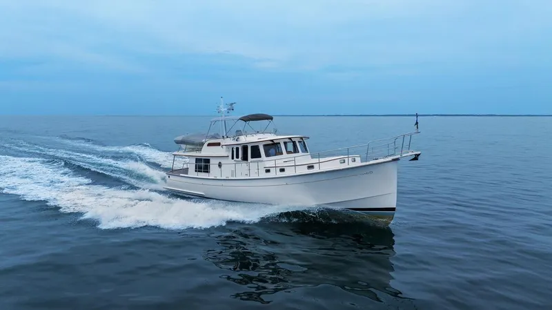 Slide: The Image of 2023 Krogen Express 52 cruising on calm ocean waters. - 2