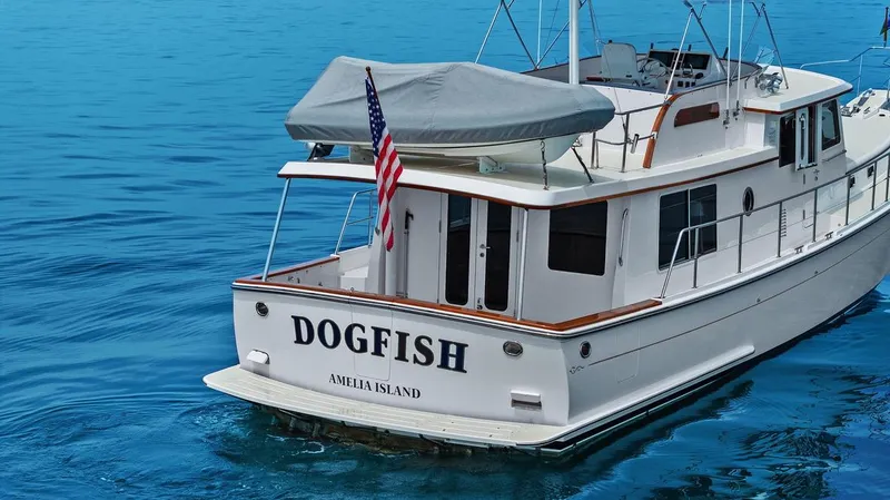Slide: The Image of 2023 Krogen Express 52 yacht named "Dogfish" on blue water near Amelia Island. - 20