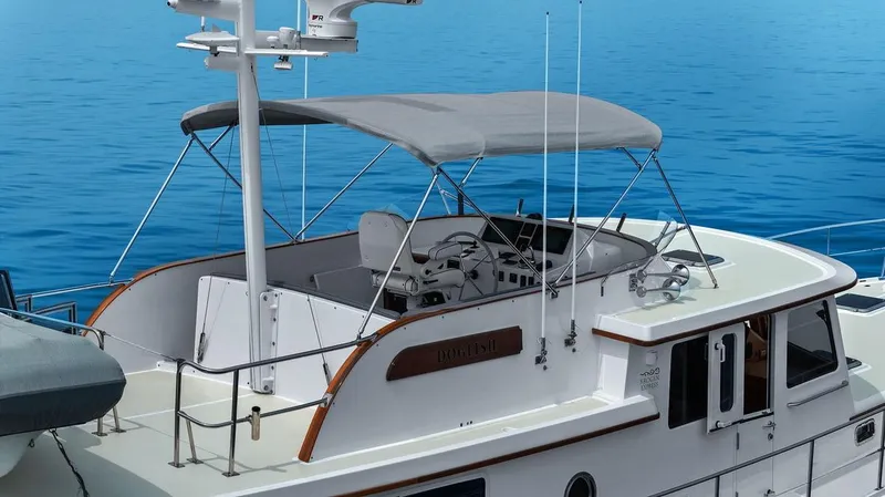 Slide: The Image of 2023 Krogen Express 52 yacht with canopy, cruising on calm blue waters. - 24