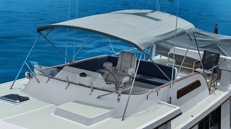 Slide: The Image of 2023 Krogen Express 52 yacht with shaded seating area on blue water. - 25