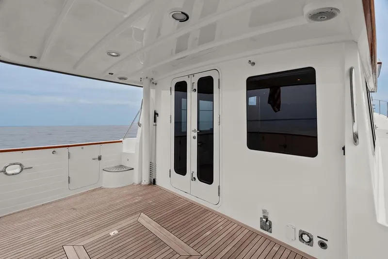 Slide: The Image of 2023 Krogen Express 52 yacht deck with wooden flooring and ocean view. - 27