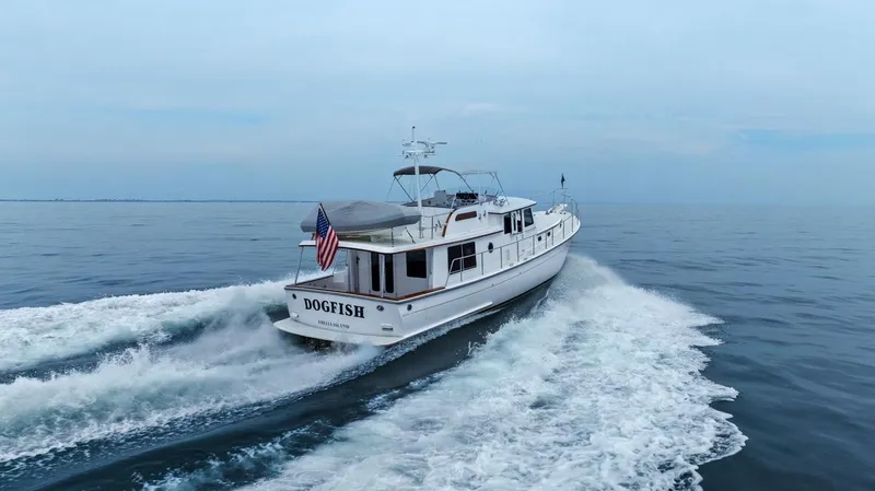 Slide: The Image of 2023 Krogen Express 52 yacht cruising on open water, rear view. - 3