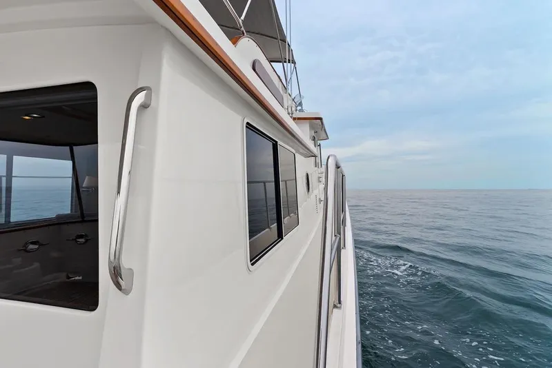 Slide: The Image of 2023 Krogen Express 52 yacht cruising on open sea under clear sky. - 30