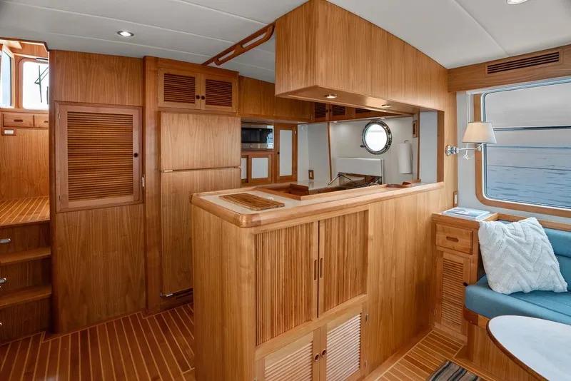 Slide: The Image of Luxurious 2023 Krogen Express 52 yacht interior with wooden cabinetry and cozy seating area. - 37