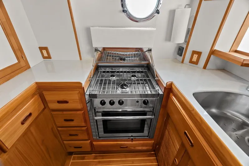 Slide: The Image of Modern kitchen in 2023 Krogen Express 52 yacht with stove, sink, and wooden cabinetry. - 41
