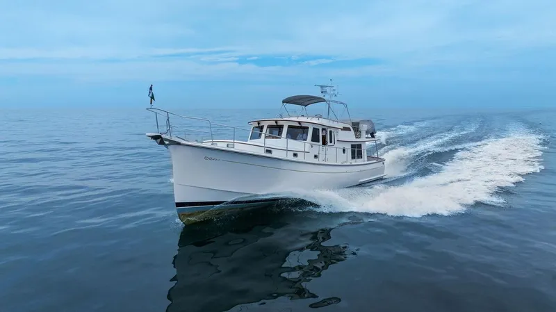 Slide: The Image of 2023 Krogen Express 52 yacht cruising on open water under clear blue skies. - 5