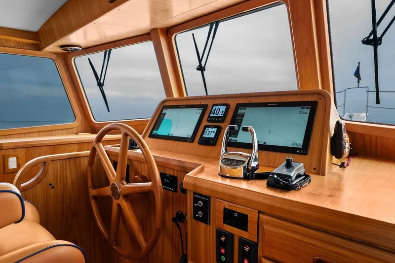 Slide: The Image of Helm of 2023 Krogen Express 52 yacht with wooden finish and modern navigation displays. - 50