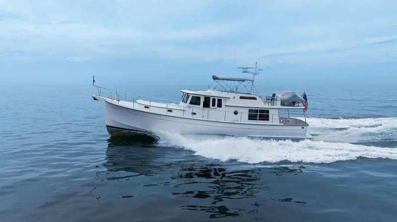 Slide: The Image of 2023 Krogen Express 52 cruising on calm ocean waters. - 6