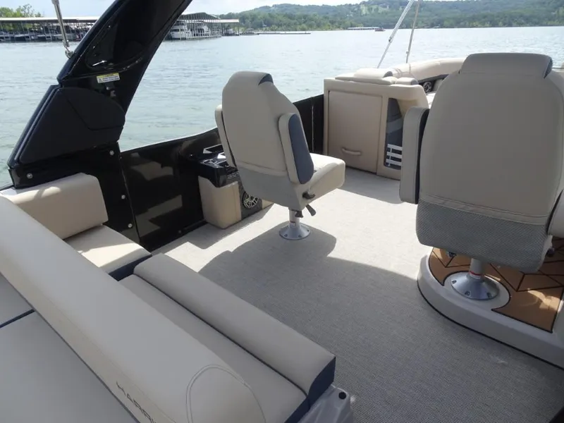 Slide: The Image of 2025 Harris Grand Mariner 250 boat interior with beige seating and lake view. - 10