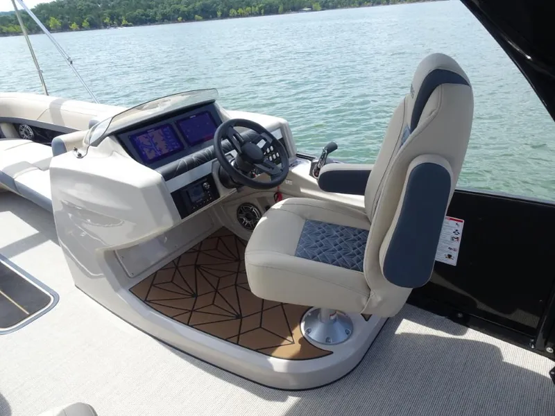 Slide: The Image of 2025 Harris Grand Mariner 250 helm with modern controls and comfortable seating on a lake. - 11