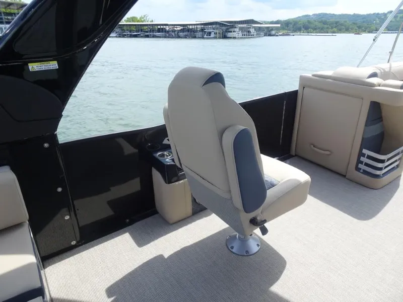 Slide: The Image of 2025 Harris Grand Mariner 250 boat interior with beige seating and lake view. - 14