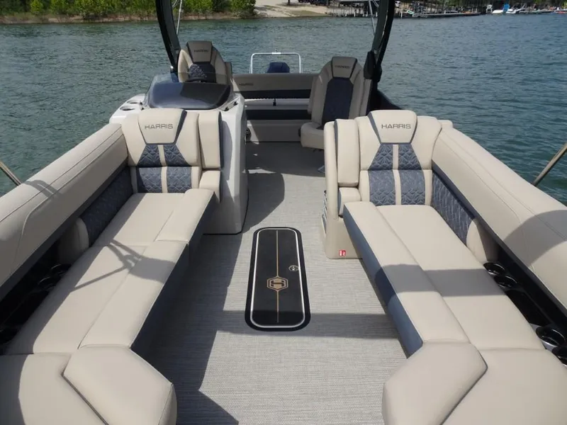 Slide: The Image of 2025 Harris Grand Mariner 250 pontoon boat interior with luxurious seating on a serene lake. - 18