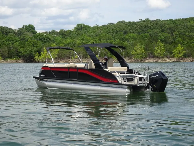 Slide: The Image of 2025 Harris Grand Mariner 250 pontoon boat on a lake with lush green shoreline. - 3