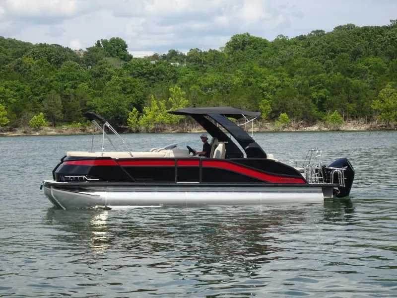 Slide: The Image of 2025 Harris Grand Mariner 250 pontoon boat on a lake with lush green shoreline. - 4