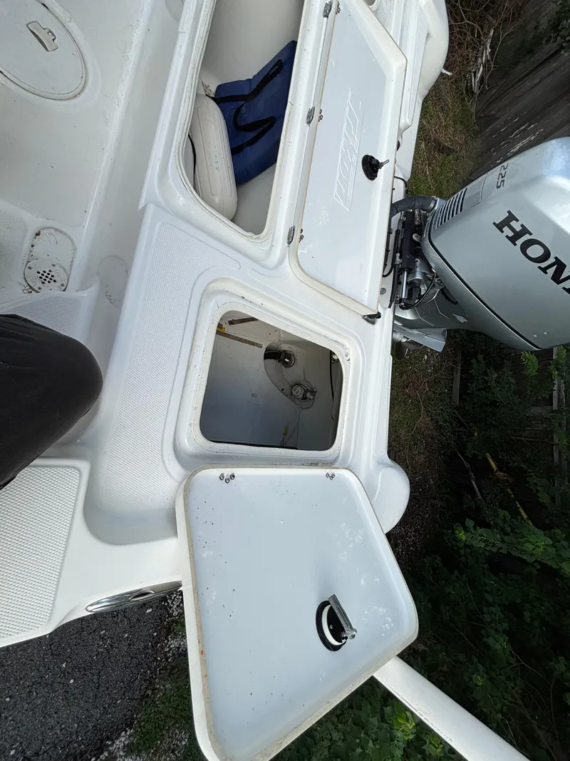 Slide: The Image of 2004 Triton LTS boat with open storage compartments and Honda outboard motor. - 11
