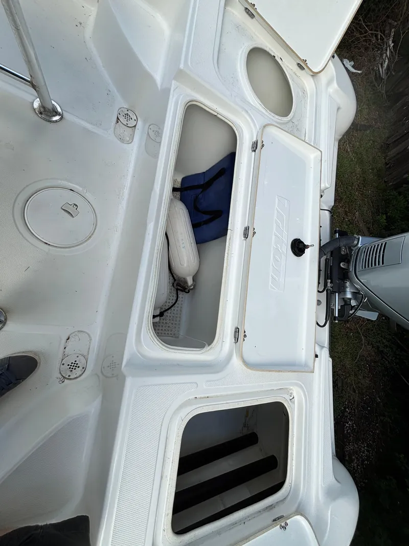 Slide: The Image of 2004 Triton LTS boat deck with storage compartments and motor. - 12
