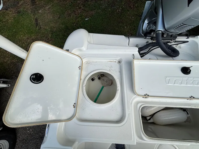 Slide: The Image of 2004 Triton LTS boat storage compartments and engine detail. - 13