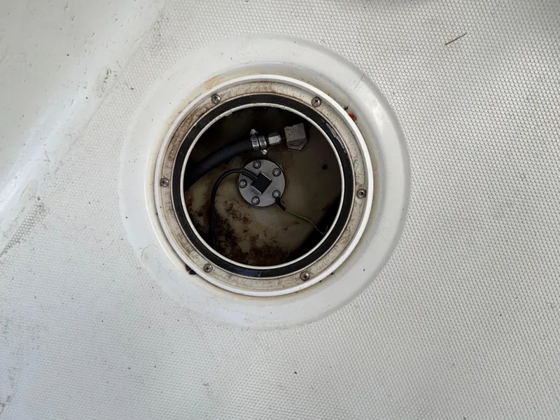 Slide: The Image of 2004 Triton LTS boat fuel tank access hatch with visible hoses and fittings. - 16