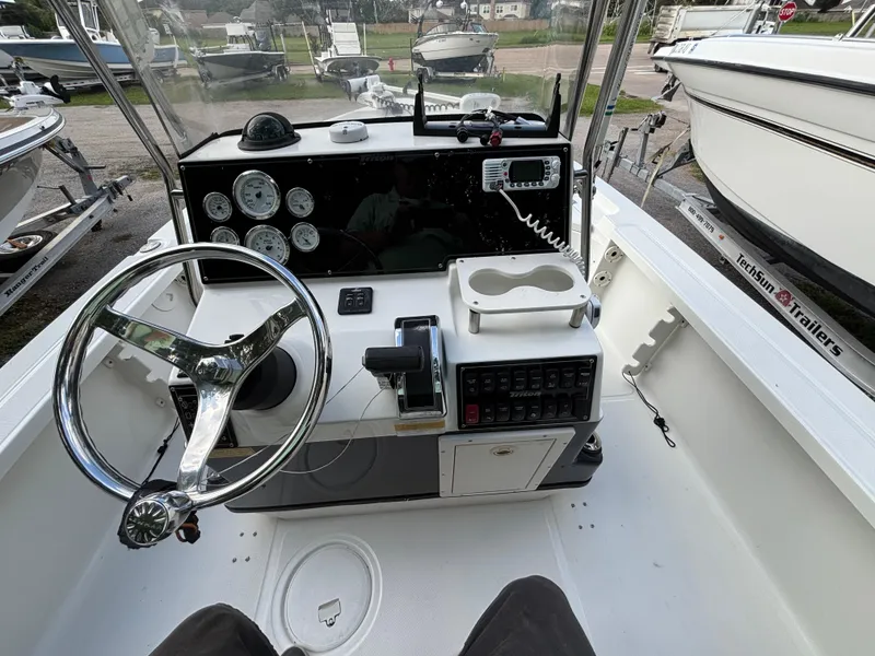 Slide: The Image of 2004 Triton LTS boat dashboard with steering wheel, gauges, and control panel. - 17