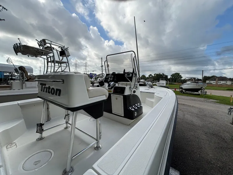 Slide: The Image of 2004 Triton LTS boat with console and seating, parked outdoors under cloudy sky. - 3