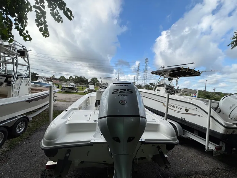 Slide: The Image of 2004 Triton LTS boat with Honda 225 VTEC engine, parked among other boats under a cloudy sky. - 6