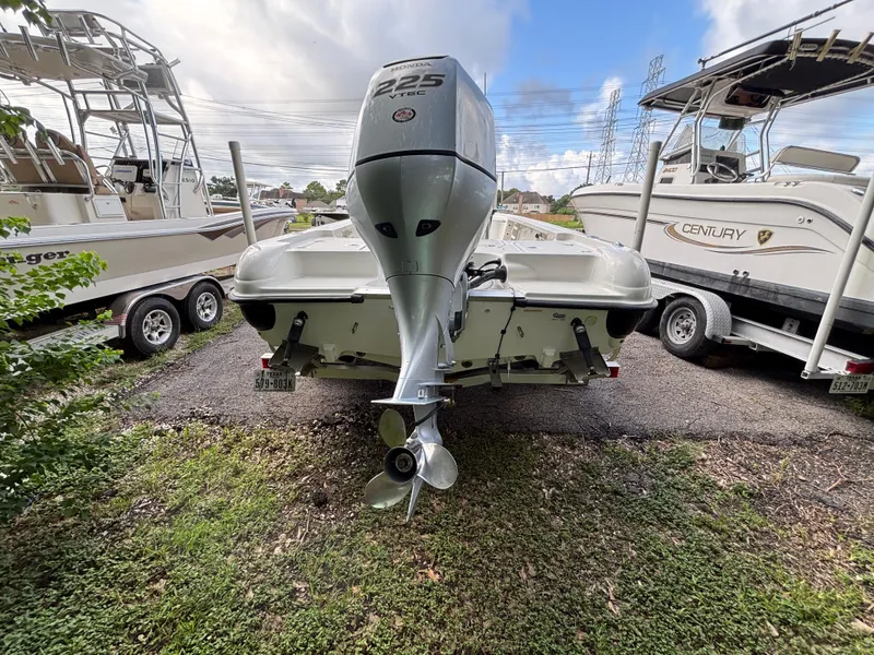 Slide: The Image of 2004 Triton LTS boat with Honda 225 VTEC engine, parked between two other boats. - 7