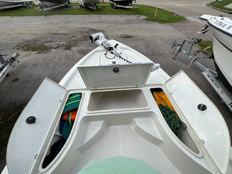 Slide: The Image of 2004 Triton LTS boat with open storage compartments, showing colorful gear and equipment. - 8