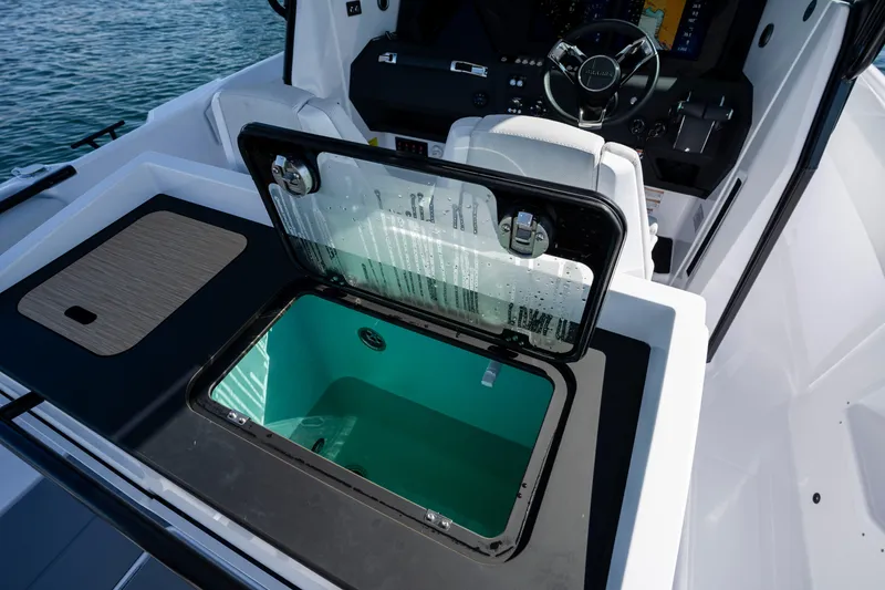 Slide: The Image of 2026 Axopar AX29 CCX boat interior with open storage compartment and steering console. - 23