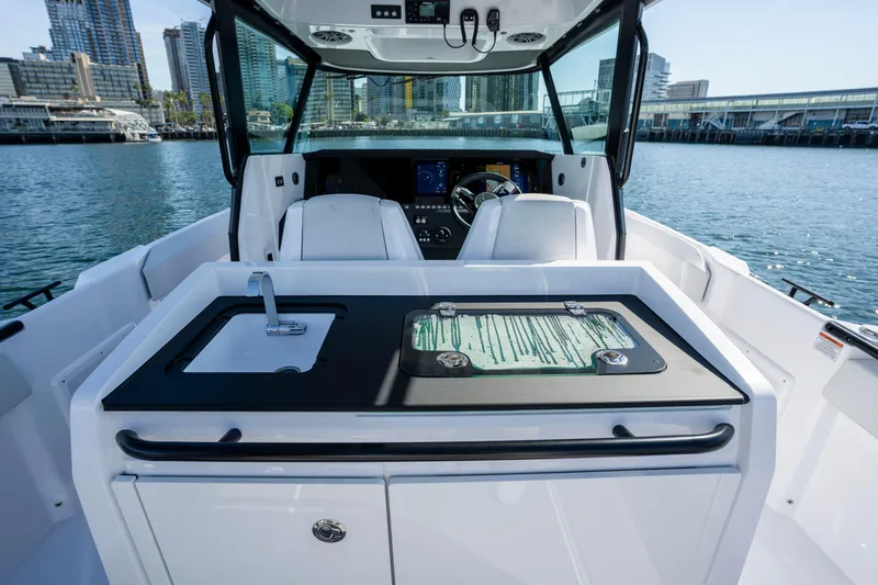 Slide: The Image of 2026 Axopar AX29 CCX boat interior with sink and city skyline in background. - 24