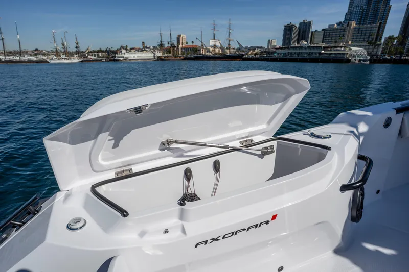 Slide: The Image of 2026 Axopar AX29 CCX boat with open storage compartment, docked in a marina. - 26