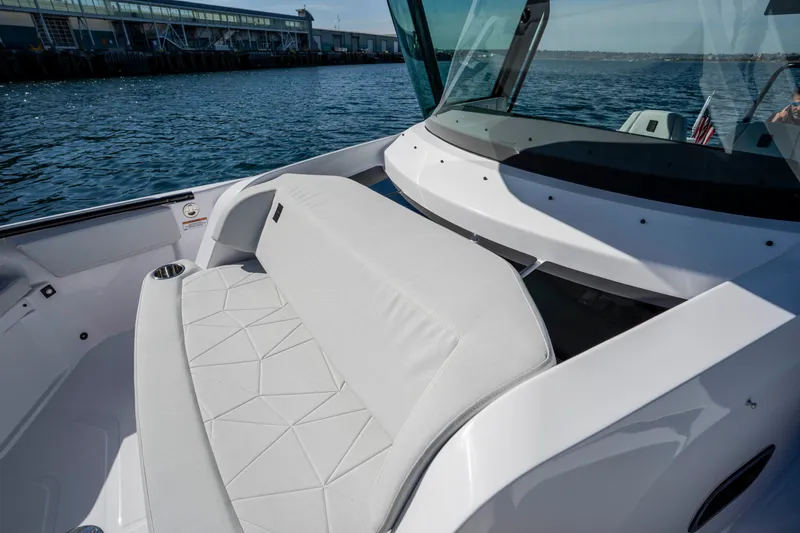 Slide: The Image of 2026 Axopar AX29 CCX boat interior with cushioned seating and ocean view. - 37