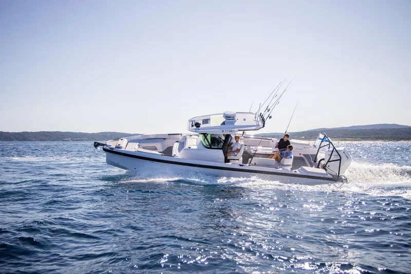 Slide: The Image of 2026 Axopar AX29 CCX cruising near city skyline on a sunny day. - 4