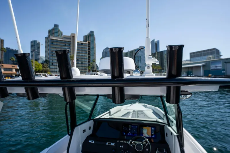 Slide: The Image of 2026 Axopar AX29 CCX boat with rod holders, city skyline in background. - 42