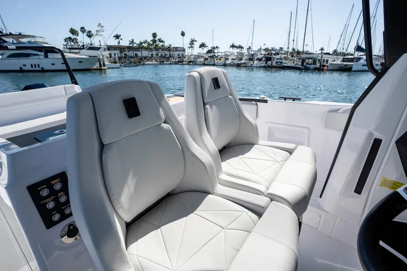 Slide: The Image of Luxury seating on 2026 Axopar AX29 CCX boat, docked in marina with yachts. - 44