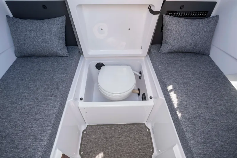 Slide: The Image of 2026 Axopar AX29 CCX boat interior with hidden toilet and cushioned seating. - 48