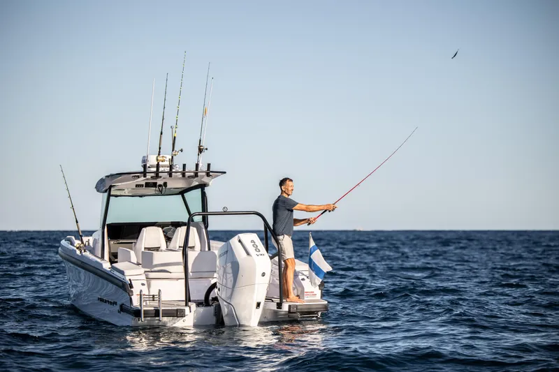 Slide: The Image of 2026 Axopar AX29 CCX boat cruising in urban waterfront setting with city skyline. - 5