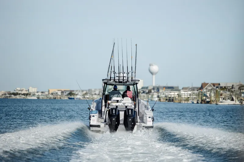 Slide: The Image of 2026 Axopar AX29 CCX cruising on a calm sea near a marina. - 7